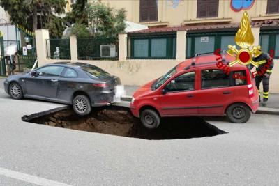 Auto in bilico sulla maxi voragine