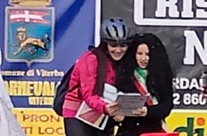 Viterbo – La sindaca Chiara Frontini mascherata da ciclista ascolta il discorso della “sindachetta”